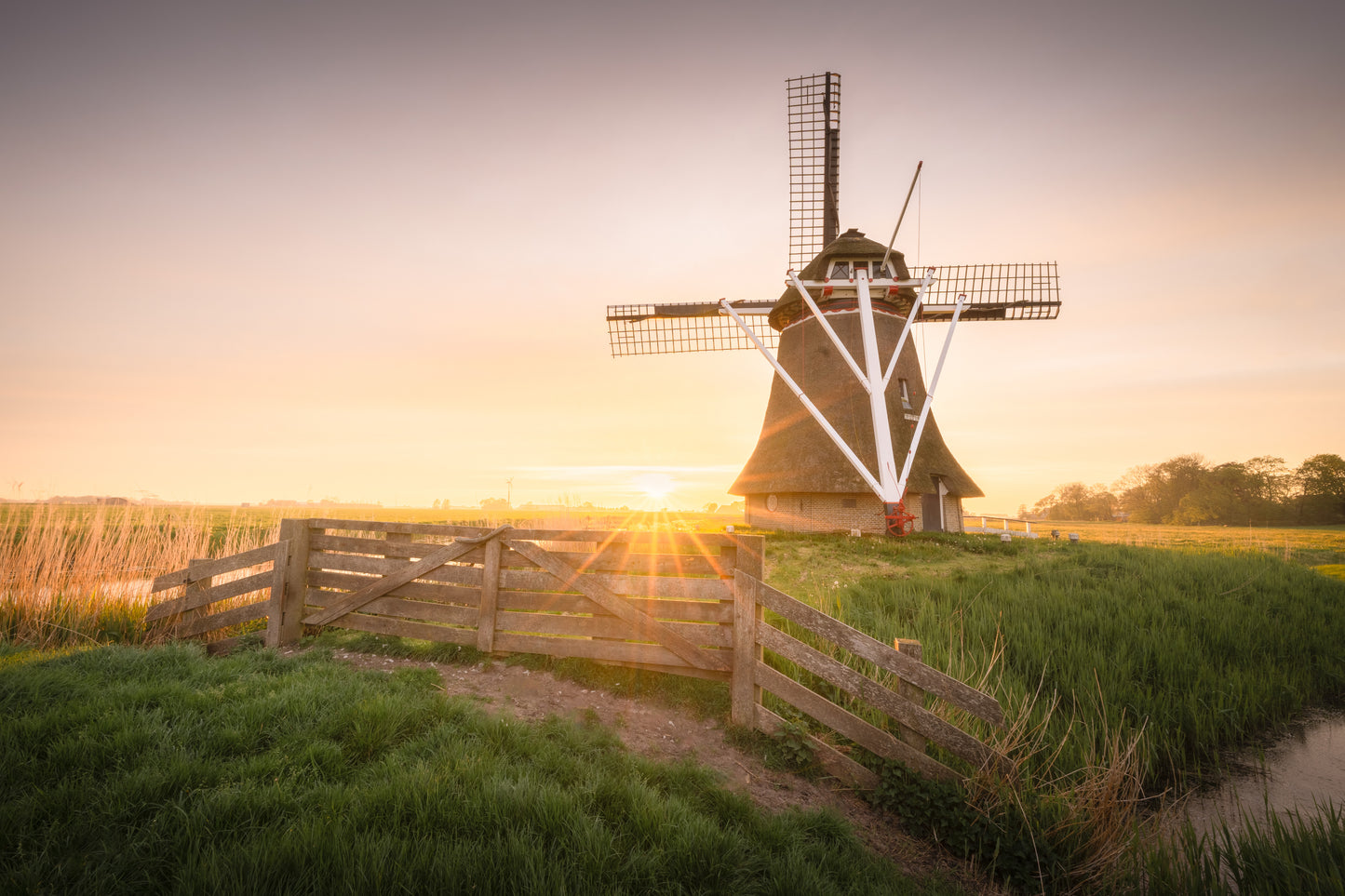 Dibond print: "De zon zakt bijna onder achter de Friese windmolen"